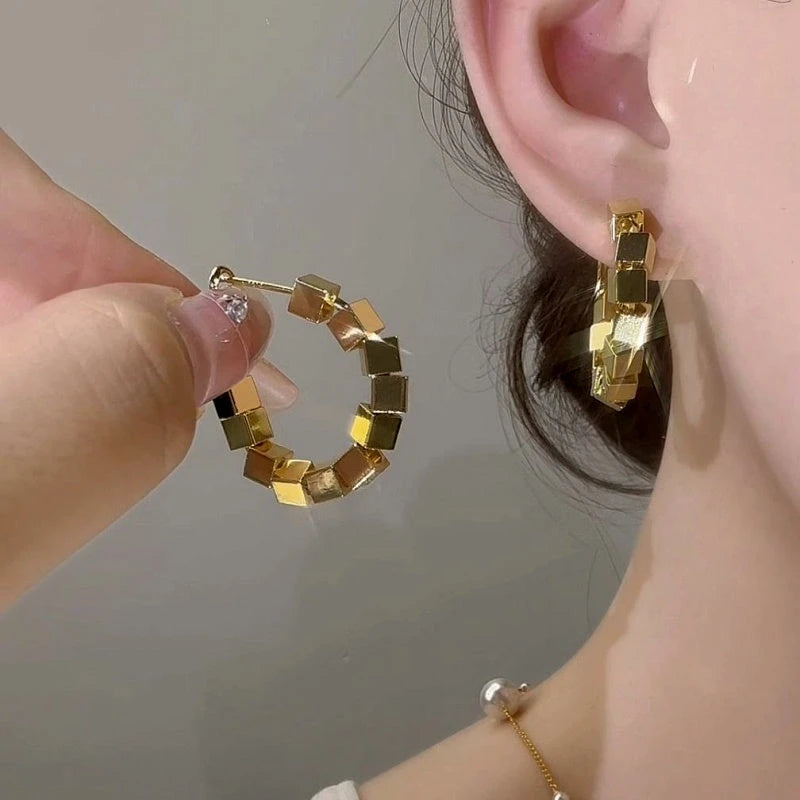 Model showcasing the dangle and style of the 14K Gold-Plated Elegant Hoop Earrings