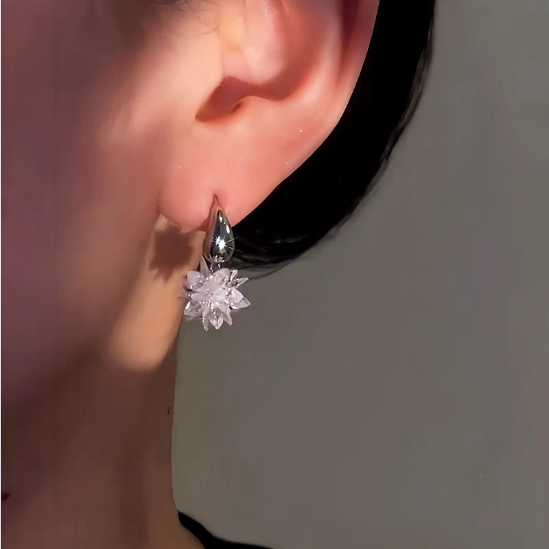 Model showcasing the dangle and style of the 14K Gold-Plated Elegant Ice Flower Earrings