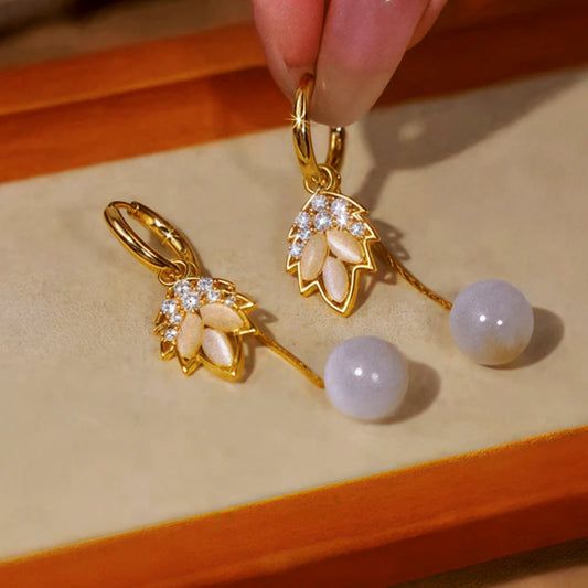 Model showcasing the dangle and style of the 14K Gold-Plated Elegant Jade Leaf Bead Tassel Earrings