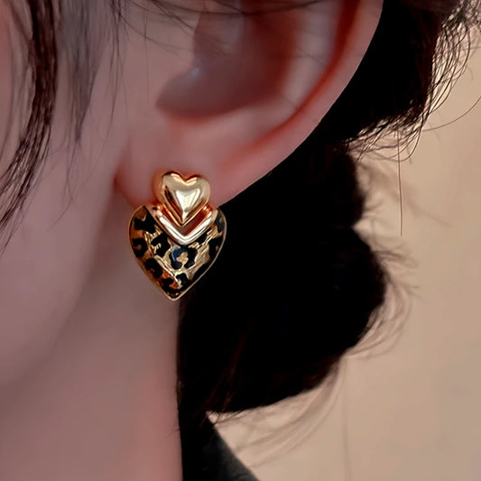 Model showcasing the dangle and style of the 14K Gold-Plated Elegant Leopard Heart-Design Earrings