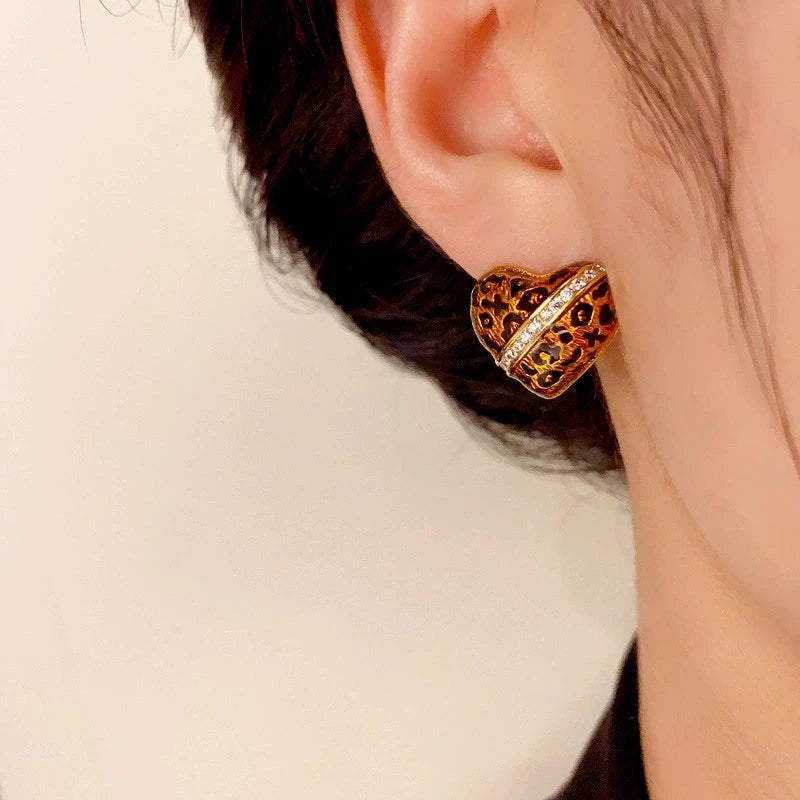 Model showcasing the dangle and style of the 14K Gold-Plated Elegant Leopard Heart Stud Earrings