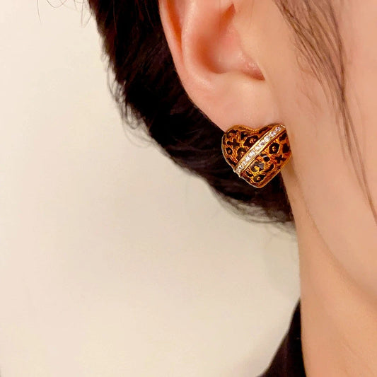 Model showcasing the dangle and style of the 14K Gold-Plated Elegant Leopard Heart Stud Earrings