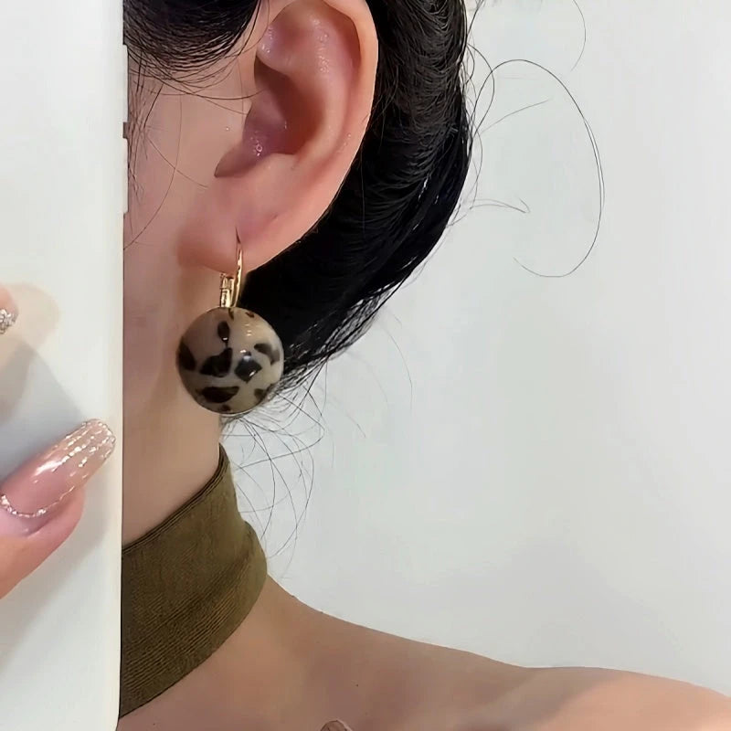 Close-up detail of the sparkling zircons and plating on the Leopard Print Ball Earrings