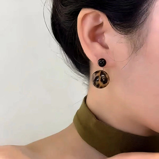 Model showcasing the dangle and style of the 14K Gold-Plated Elegant Leopard Print Bead Earrings