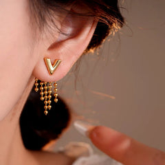 Model showcasing the dangle and style of the 14K Gold-Plated Elegant Letter V Tassel Earrings