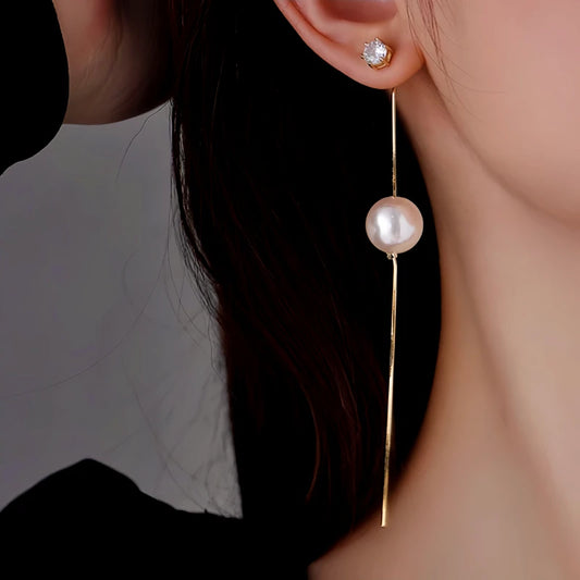 Model showcasing the dangle and style of the 14K Gold-Plated Elegant Long Pearl Tassel Earrings