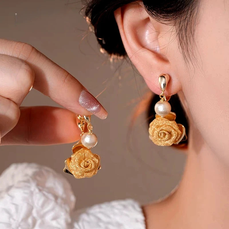 Angled view of the 14K Gold-Plated Elegant Mesh Rose Bead Cross Earrings