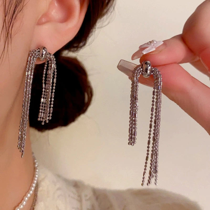 Model showcasing the dangle and style of the 14K Gold-Plated Elegant Metal Long Chain Tassel Earrings