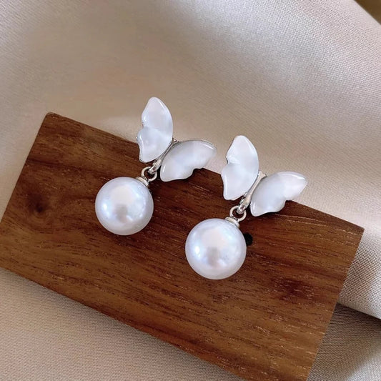 Model showcasing the dangle and style of the 14K Gold-Plated Elegant Mother-Of-Pearl Butterfly Earrings