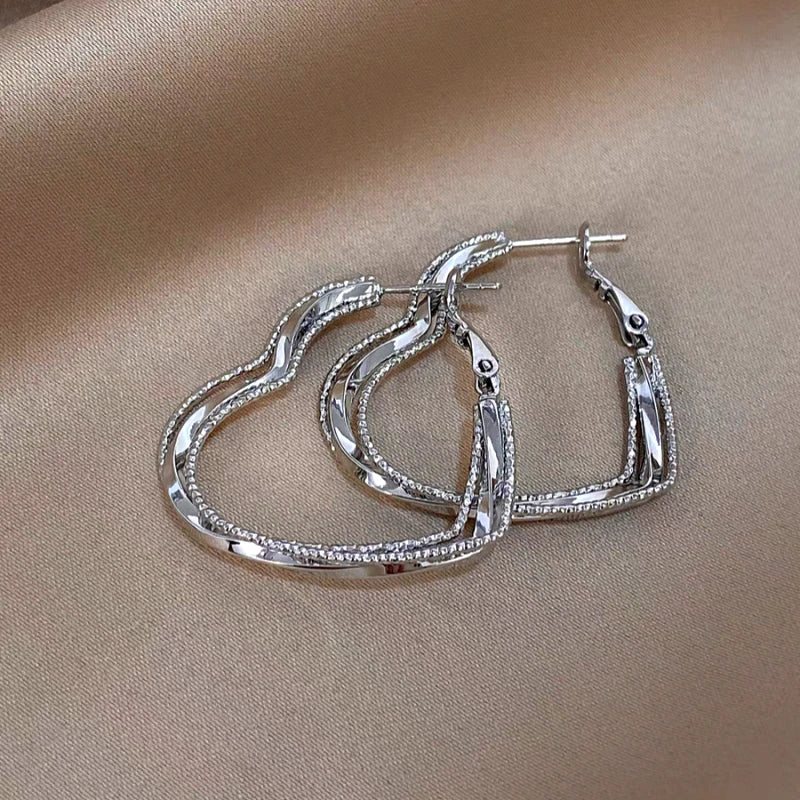 Model showcasing the dangle and style of the 14K Gold-Plated Elegant Multi-Layer Heart Earrings