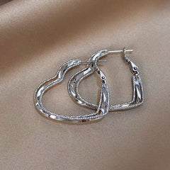 Model showcasing the dangle and style of the 14K Gold-Plated Elegant Multi-Layer Heart Earrings