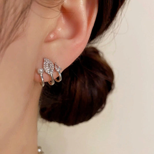 Model showcasing the dangle and style of the 14K Gold-Plated Elegant Multi-Layer Zircon Leaf Pearl Stud Earrings