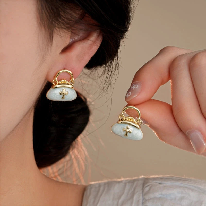 Model showcasing the dangle and style of the 14K Gold-Plated Elegant Oil Drop Bag Earrings