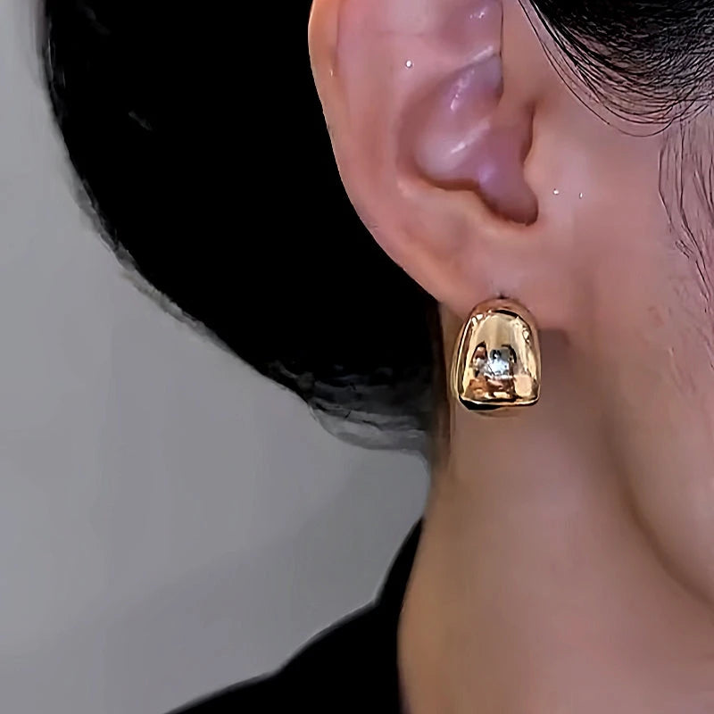 Model showcasing the dangle and style of the 14K Gold-Plated Elegant Oil Drop Earrings