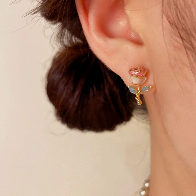 Model showcasing the dangle and style of the 14K Gold-Plated Elegant Oil Drop Rose Stud Earrings