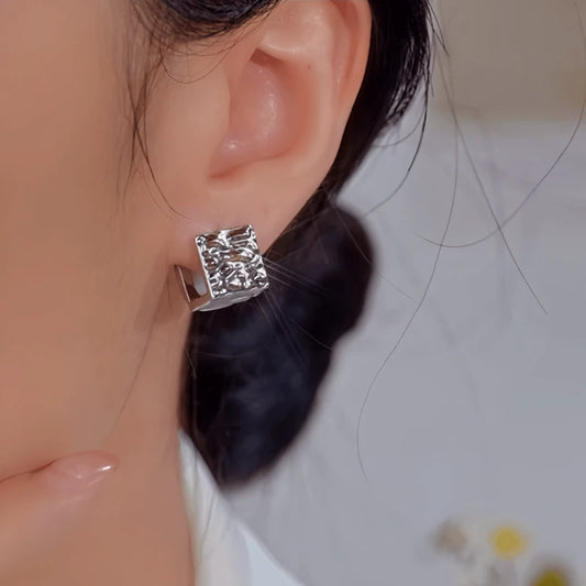 Model showcasing the dangle and style of the 14K Gold-Plated Elegant Pearl Double-Sided Textured Earrings