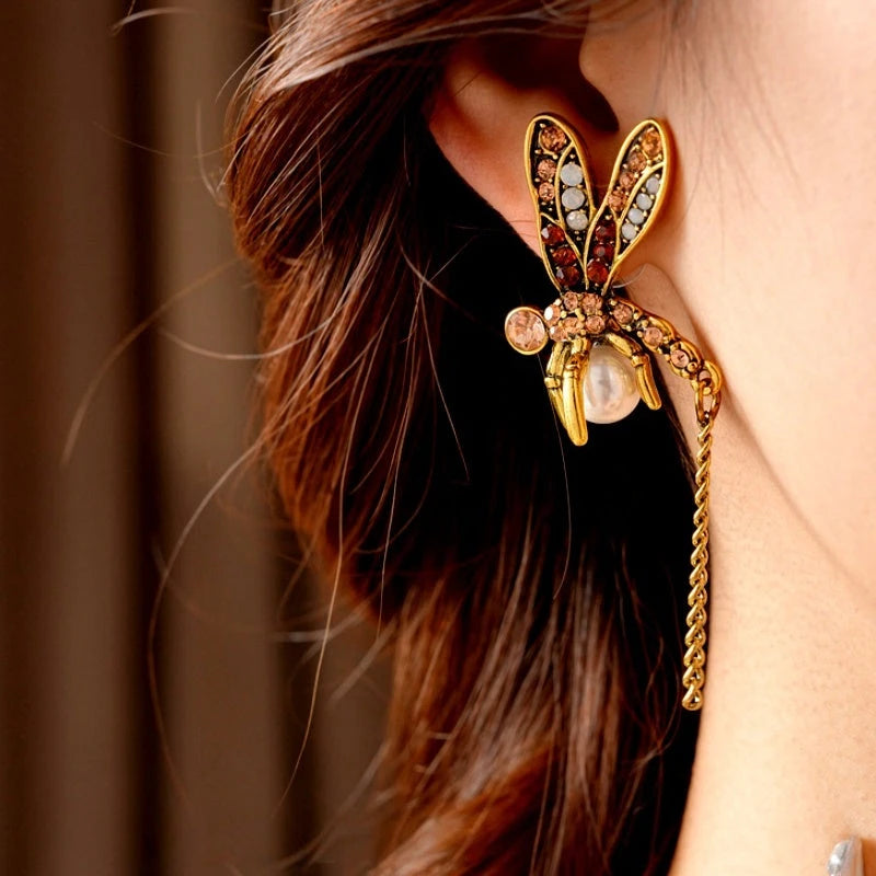 Model showcasing the dangle and style of the 14K Gold-Plated Elegant Pearl Dragonfly Tassel Earrings