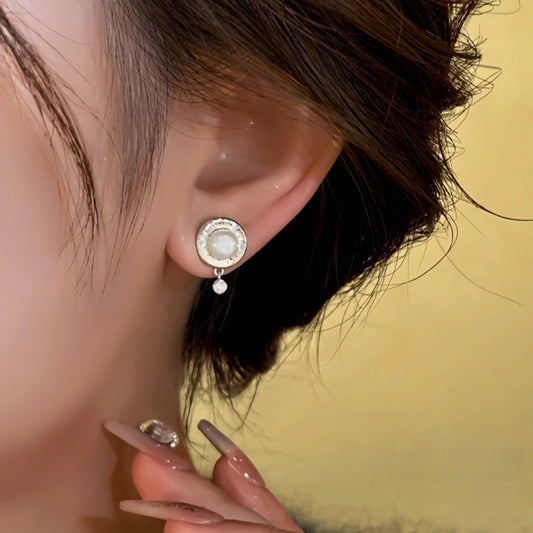 Model showcasing the dangle and style of the 14K Gold-Plated Elegant Pearl Earrings