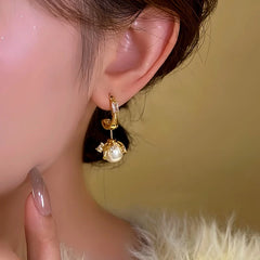 Model showcasing the dangle and style of the 14K Gold-Plated Elegant Pearl Earrings