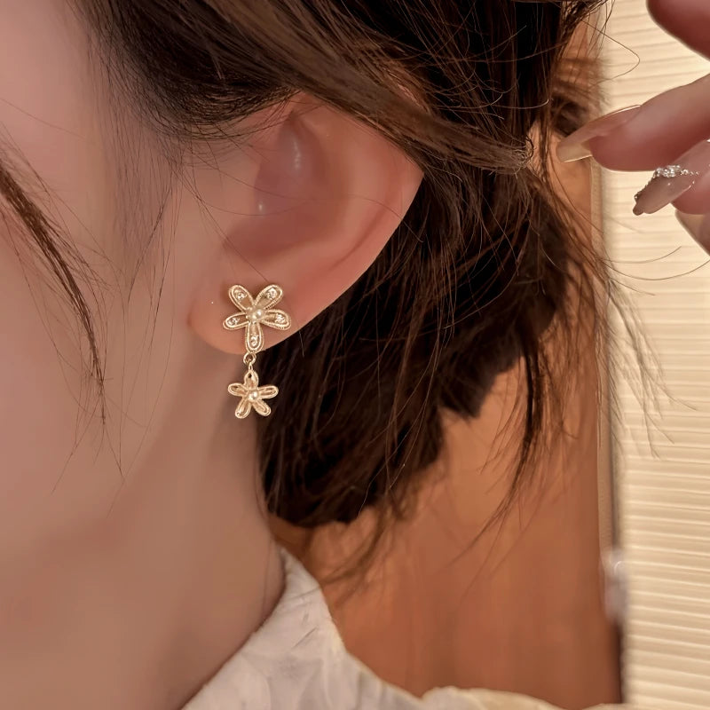Model showcasing the dangle and style of the 14K Gold-Plated Elegant Pearl Flower Earrings
