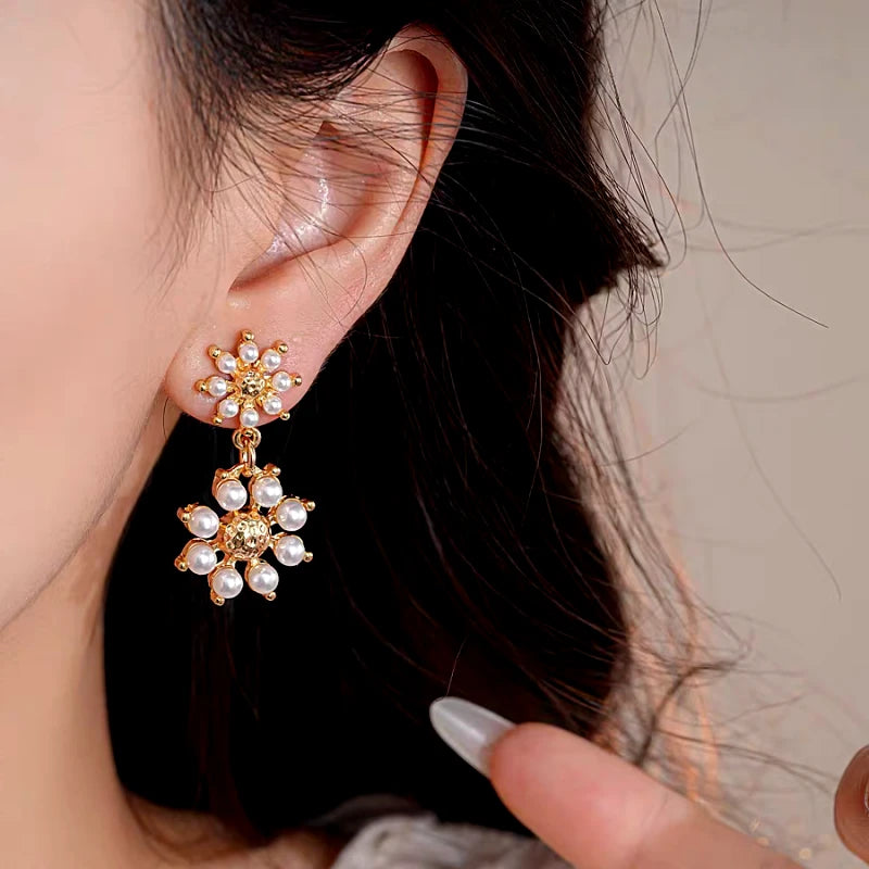 Model showcasing the dangle and style of the 14K Gold-Plated Elegant Pearl Flower Tassel Earrings