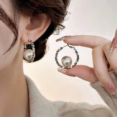 Model showcasing the dangle and style of the 14K Gold-Plated Elegant Pearl Hoop Earrings