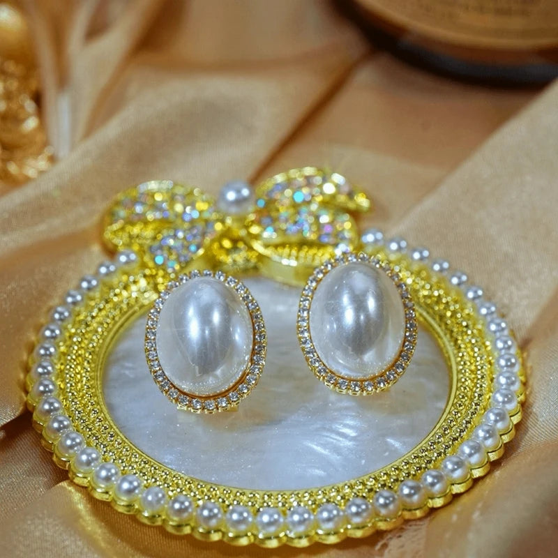 Angled view of the 14K Gold-Plated Elegant Pearl Stud Earrings