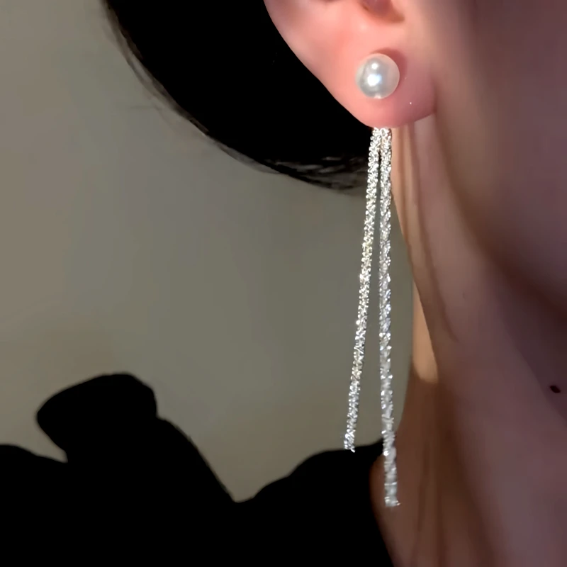 Model showcasing the dangle and style of the 14K Gold-Plated Elegant Pearl Tassel Earrings