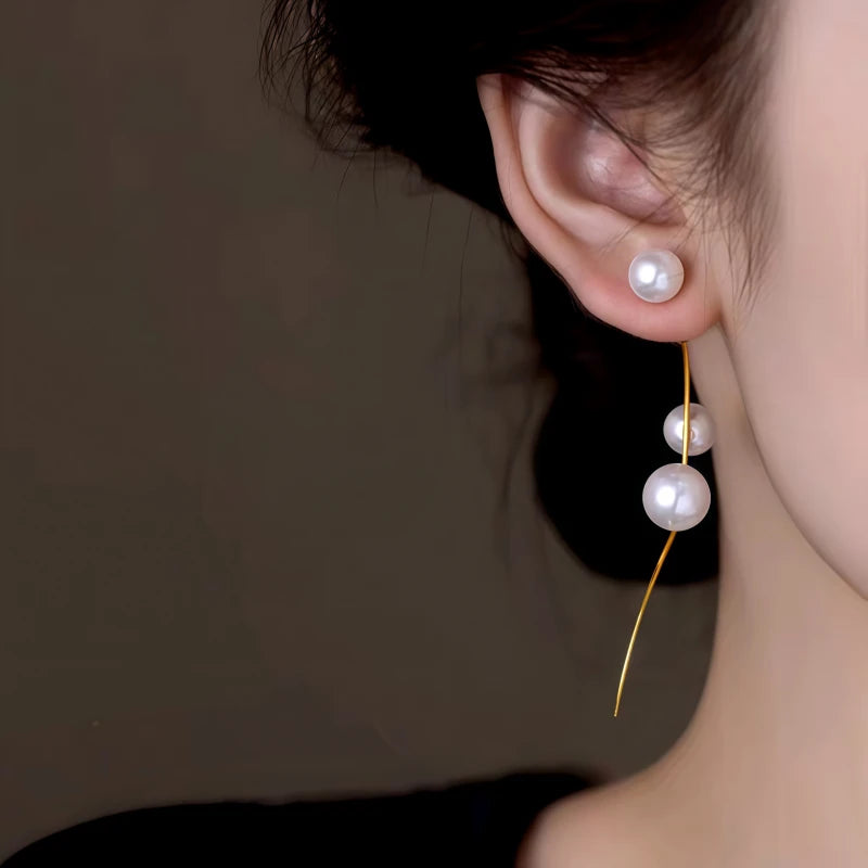 Model showcasing the dangle and style of the 14K Gold-Plated Elegant Pearl Tassel Earrings