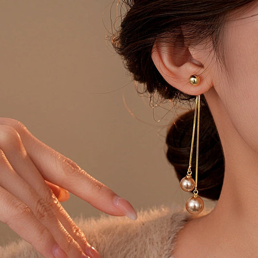 Model showcasing the dangle and style of the 14K Gold-Plated Elegant Pearl Tassel Earrings
