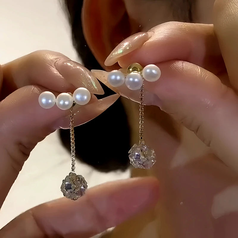 Angled view of the 14K Gold-Plated Elegant Pearl Zircon Ball Tassel Earrings