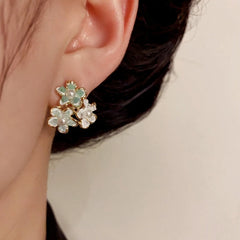 Model showcasing the dangle and style of the 14K Gold-Plated Elegant Petal Flower Stud Earrings
