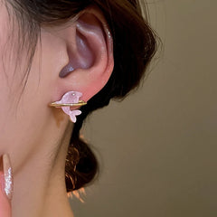 Model showcasing the dangle and style of the 14K Gold-Plated Elegant Pink Dolpin Stud Earrings