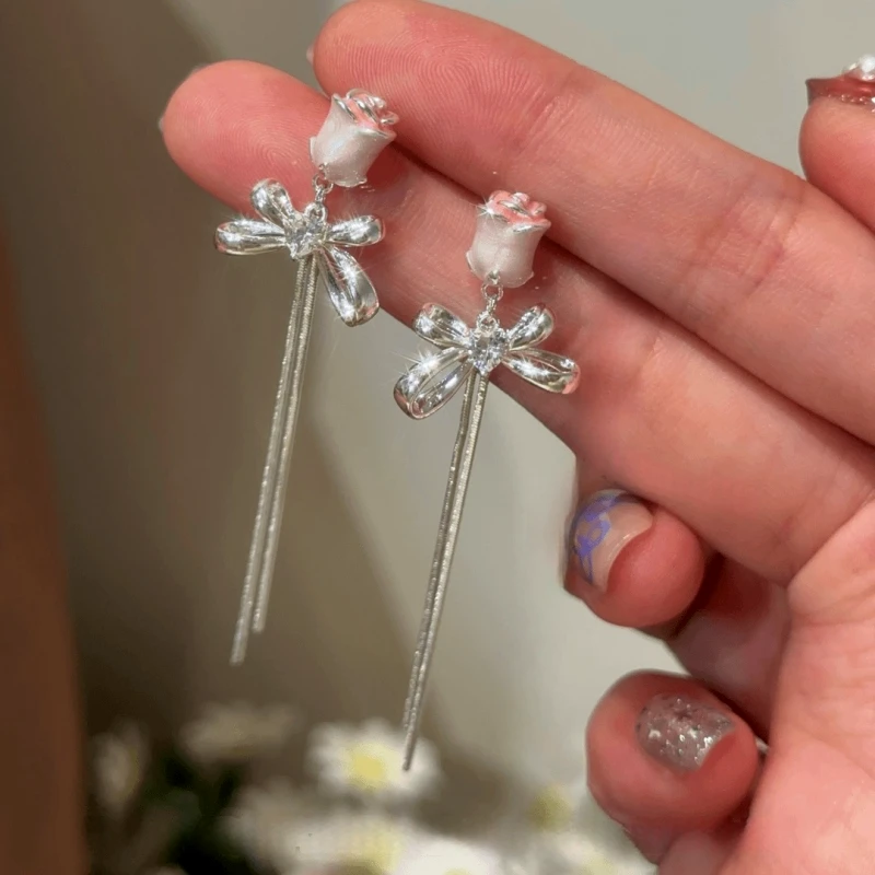 Model showcasing the dangle and style of the 14K Gold-Plated Elegant Pink Rose Zircon Heart  Bow Tassel Earrings