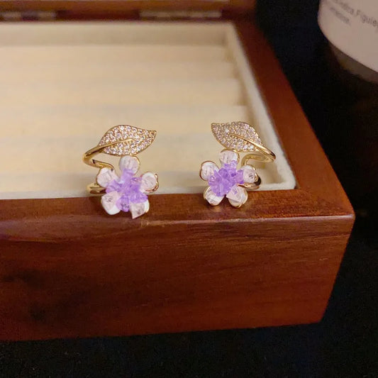 Model showcasing the dangle and style of the 14K Gold-Plated Elegant Purple Crystal Flower Zircon Leaf Stud Earrings