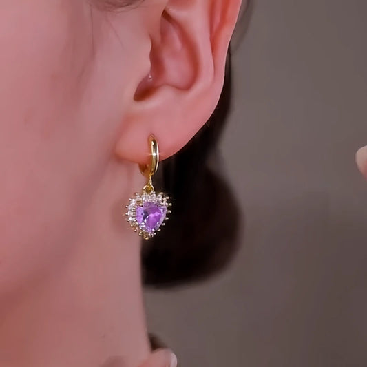 Model showcasing the dangle and style of the 14K Gold-Plated Elegant Purple Diamond Heart Earrings
