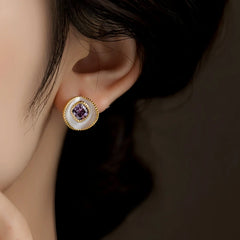 Model showcasing the dangle and style of the 14K Gold-Plated Elegant Purple Diamond Stud Earrings