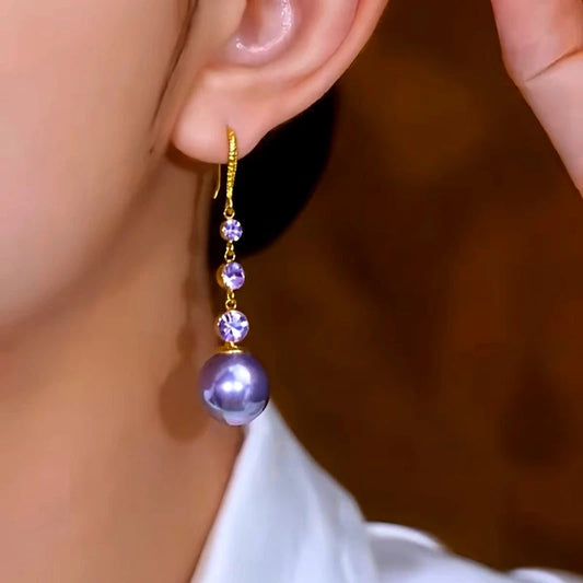 Model showcasing the dangle and style of the 14K Gold-Plated Elegant Purple Pearl Zircon Ear Hook Earrings