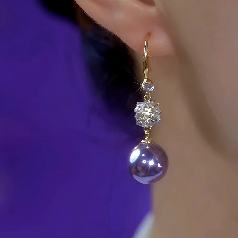 Model showcasing the dangle and style of the 14K Gold-Plated Elegant Purple Pearl Zircon Earrings