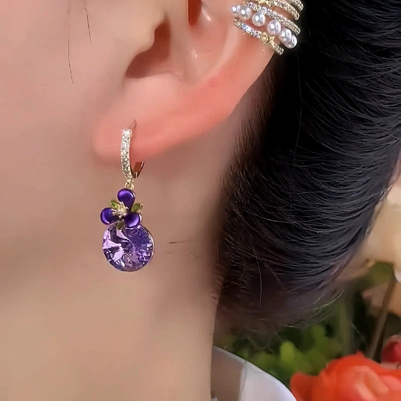 Model showcasing the dangle and style of the 14K Gold-Plated Elegant Purple Zircon Diamond Flower Earrings