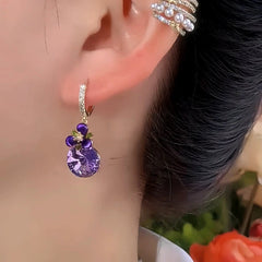 Model showcasing the dangle and style of the 14K Gold-Plated Elegant Purple Zircon Diamond Flower Earrings