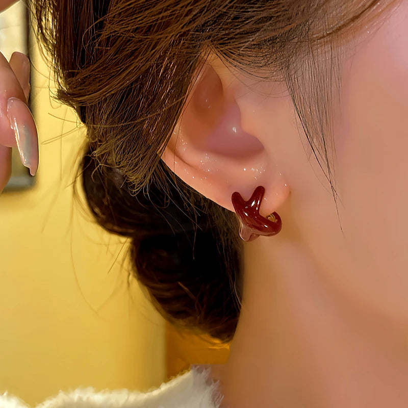 Close-up detail of the sparkling zircons and plating on the Red Cross Earrings