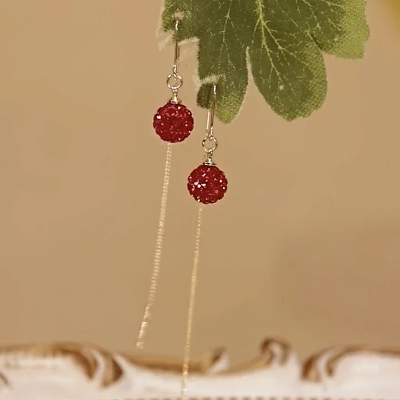 Angled view of the 14K Gold-Plated Elegant Red Crystal Ball Threader Earrings