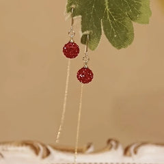 Angled view of the 14K Gold-Plated Elegant Red Crystal Ball Threader Earrings