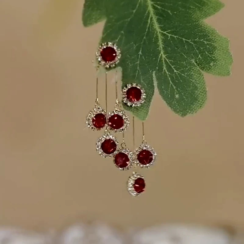 Angled view of the 14K Gold-Plated Elegant Red Crystal Tassel Earrings