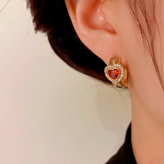 Model showcasing the dangle and style of the 14K Gold-Plated Elegant Red Heart Hoop Earrings