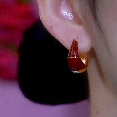Model showcasing the dangle and style of the 14K Gold-Plated Elegant Red Oil Drop Earrings