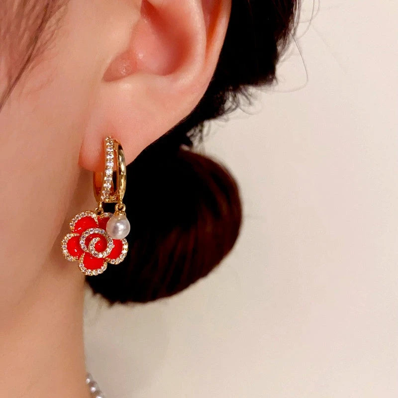 Model showcasing the dangle and style of the 14K Gold-Plated Elegant Red Oil Drop Flower Pearl Earrings