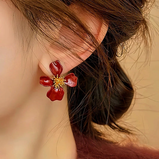 Model showcasing the dangle and style of the 14K Gold-Plated Elegant Red Petal Flower Earrings