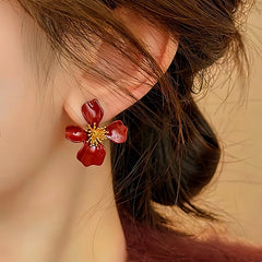 Model showcasing the dangle and style of the 14K Gold-Plated Elegant Red Petal Flower Earrings